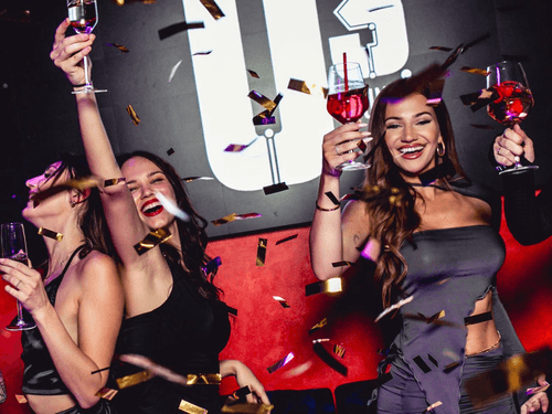 Drei feiernde Frauen im Confetti-Regen